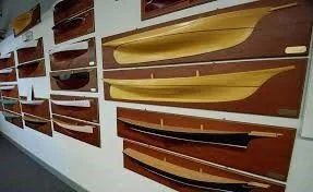 A wall display of carved wooden half hull models from the carving workshops