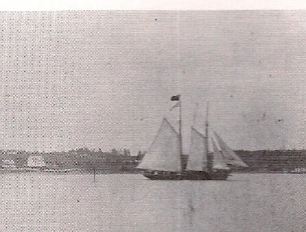 Vintage photograph of a two-masted schooner under sail off Mahone Bay