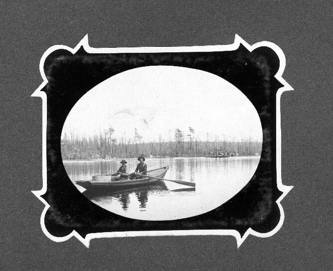 Historic photograph of two men rowing on Little Mushamush Lake