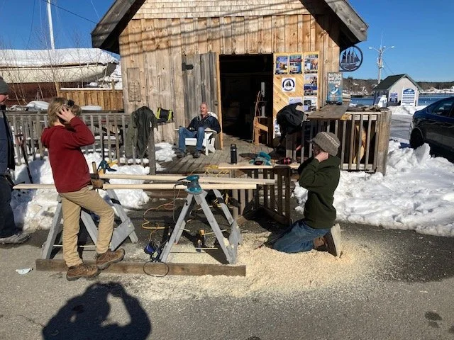 Students working on oars outside the Heritage Boatyard shed