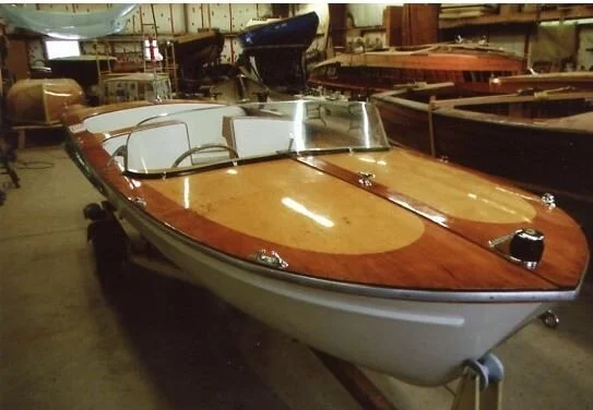 Fully restored Plycraft 12-foot mahogany runabout on a trailer in the boat shed
