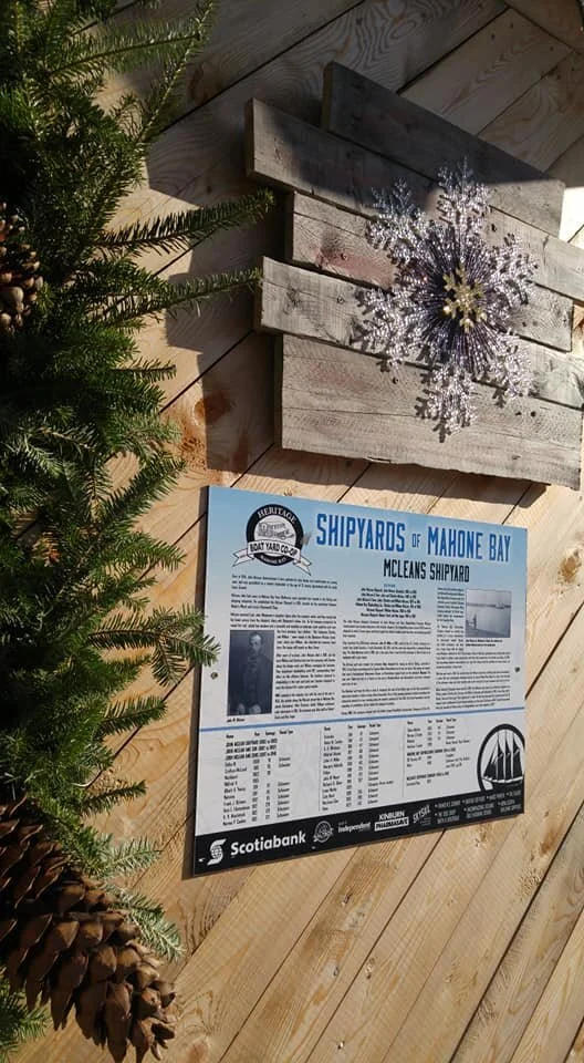 The McLean's Shipyard panel mounted on a barn-board backing beside the Co-op Christmas wreath